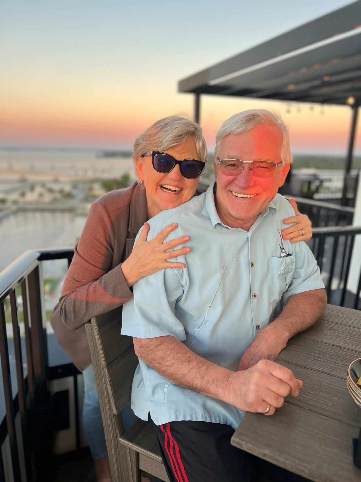 Ted and Ewa smiling together at sunset