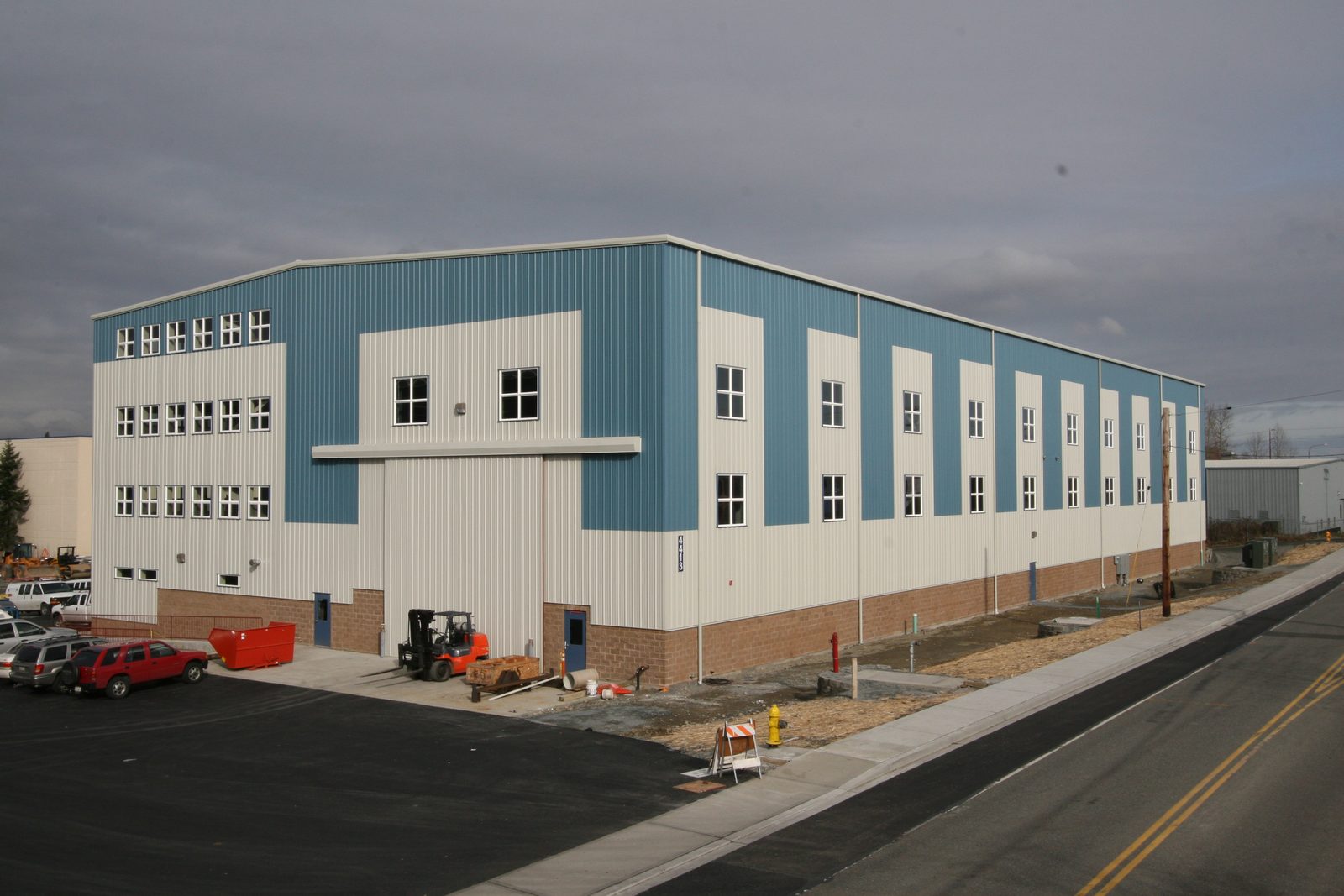 Large multi-story steel industrial manufacturing building with blue and white panels