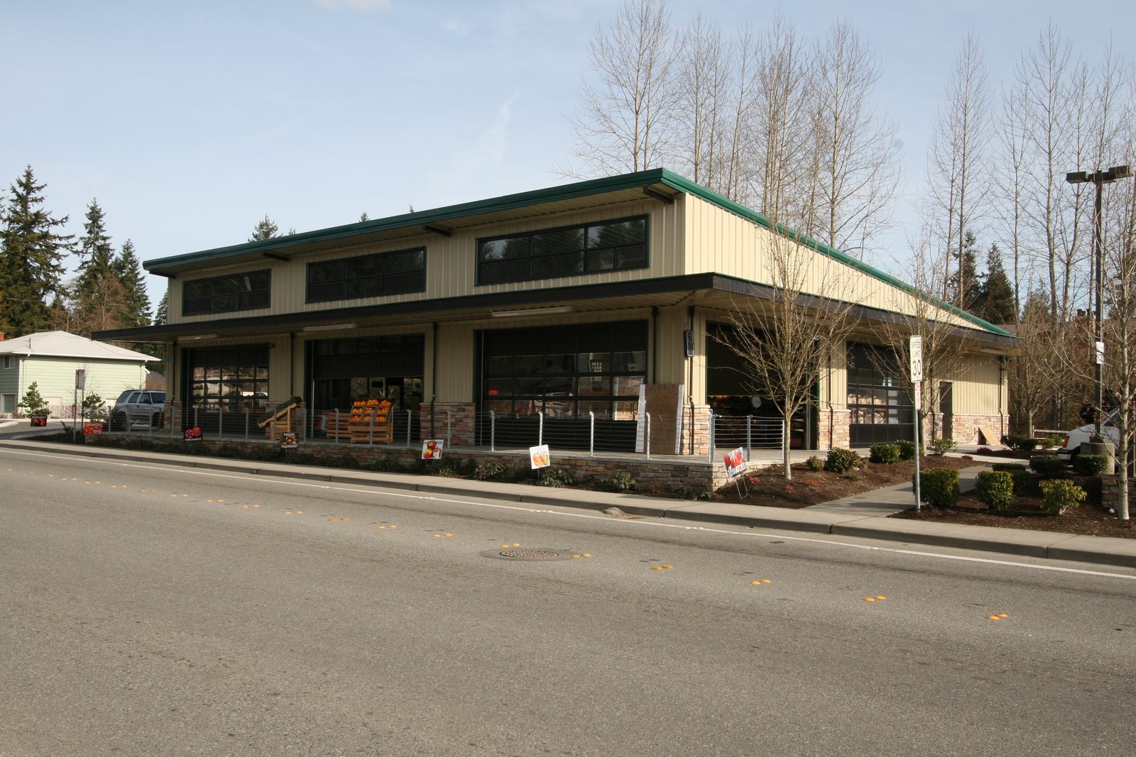 Two-story steel building with a green standing-seam roof used as a retail farm market