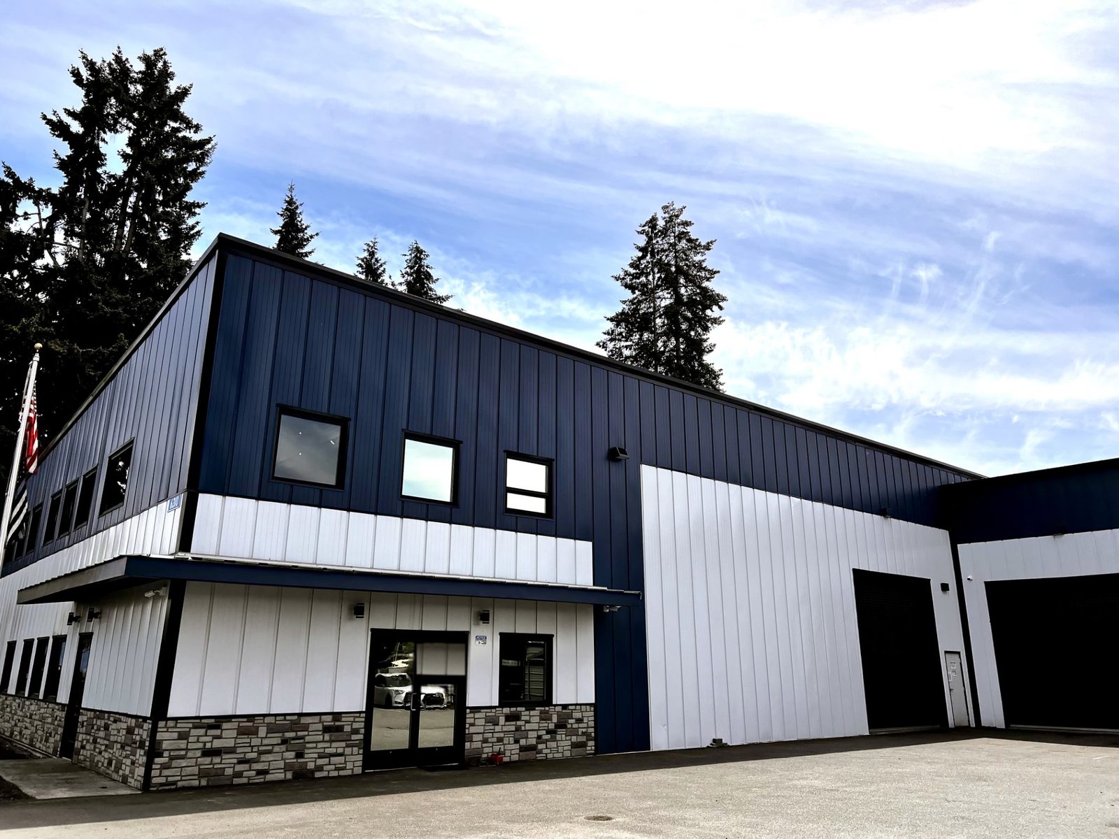 Navy and white steel office and shop building with large overhead doors