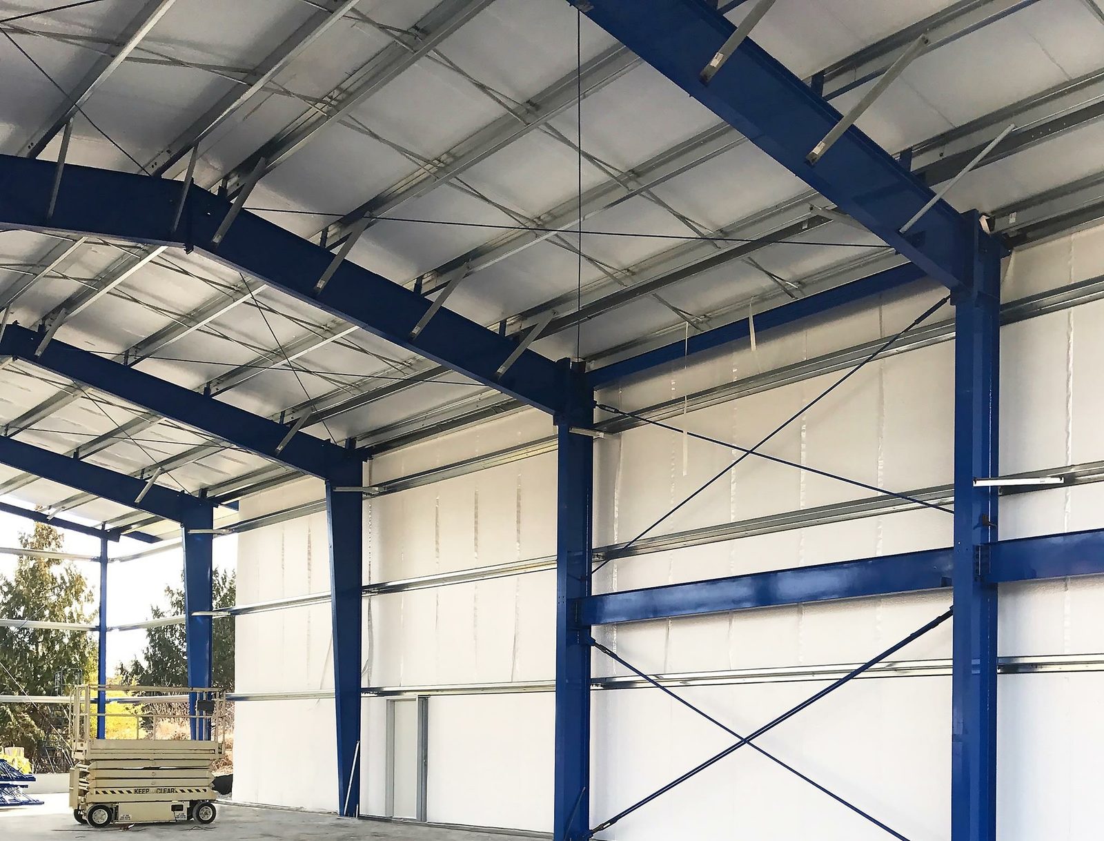 Interior view of blue structural steel framing inside a large clear-span building